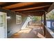 A covered back porch with ceiling fan and wood flooring looks out over a wooded area at 389 Oglesby Bridge Se Rd, Conyers, GA 30094