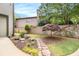 Landscaped backyard with stone walkway, lush garden beds, stone retaining wall, mature trees, and a charming Japanese maple at 612 Concord Lake Se Cir, Smyrna, GA 30082