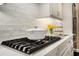 Close-up of the gas cooktop and white subway tile backsplash in a gourmet kitchen at 612 Concord Lake Se Cir, Smyrna, GA 30082