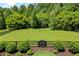 Spacious, manicured backyard with lush green grass, privacy fence, and mature trees provides a serene and private retreat at 115 Trinity Hollow Dr, Canton, GA 30115