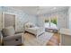 Bright bedroom featuring patterned wallpaper, a ceiling fan, chair, and a window seat overlooking the outdoor greenery at 115 Trinity Hollow Dr, Canton, GA 30115