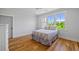 Sunlit bedroom with hardwood floors, grey walls and a window overlooking the lush landscape at 115 Trinity Hollow Dr, Canton, GA 30115