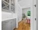 Elegant butler's pantry featuring gray cabinets, marble countertop, brass hardware and hardwood floors with an adjacent sunny breakfast nook at 115 Trinity Hollow Dr, Canton, GA 30115