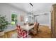 Bright dining room featuring hardwood floors, large windows, and a rustic dining table with wicker chairs at 115 Trinity Hollow Dr, Canton, GA 30115
