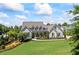 Beautiful single Gathering home with manicured front lawn and garden and charming white exterior at 115 Trinity Hollow Dr, Canton, GA 30115