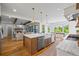Eat-in kitchen features stainless steel appliances, modern lighting, and views into the living and dining rooms at 115 Trinity Hollow Dr, Canton, GA 30115