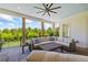 Spacious outdoor patio with a cozy seating area, a ceiling fan, and expansive views of the lush backyard at 115 Trinity Hollow Dr, Canton, GA 30115
