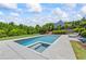 Backyard with a beautiful in-ground pool and hot tub surrounded by lush greenery, stone pavers and lounge chairs at 115 Trinity Hollow Dr, Canton, GA 30115