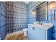 Powder room features patterned wallpaper, a modern vanity, and brick floors for added texture at 115 Trinity Hollow Dr, Canton, GA 30115