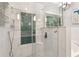 Bathroom featuring glass enclosed shower with blue tile detail and soaking tub at 4733 Julian Way, Acworth, GA 30101