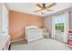 Bedroom with patterned accent wall, white crib, and window with natural light at 4733 Julian Way, Acworth, GA 30101