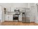 Well-lit kitchen with stainless steel appliances, white cabinets, and wood flooring at 4733 Julian Way, Acworth, GA 30101