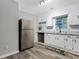 Renovated kitchen featuring white cabinets, granite countertops, stainless steel appliances, and modern backsplash at 4808 Oak Ct, Ellenwood, GA 30294