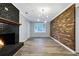 Living room featuring exposed brick wall, fireplace, and modern lighting fixture, great for entertaining at 4808 Oak Ct, Ellenwood, GA 30294
