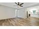 Open living room with wood floors, neutral paint, and a view into the updated kitchen with stainless appliances at 4808 Oak Ct, Ellenwood, GA 30294