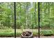 Backyard featuring a stone fire pit surrounded by lush greenery and tall trees, creating a serene outdoor space at 5258 Tallgrass Nw Way, Kennesaw, GA 30152