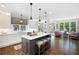 Open kitchen with a central island, pendant lights, white cabinets and view into the connected living and dining space at 5258 Tallgrass Nw Way, Kennesaw, GA 30152