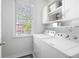 Well-lit laundry room with washer, dryer, storage cabinets, and a window at 5258 Tallgrass Nw Way, Kennesaw, GA 30152