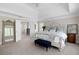 Large primary bedroom featuring a tray ceiling, shuttered windows, and an ensuite bathroom entrance at 5258 Tallgrass Nw Way, Kennesaw, GA 30152