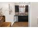 Stylish wet bar with dark cabinets, glass shelving, and a mini-fridge, perfect for entertaining guests at 5258 Tallgrass Nw Way, Kennesaw, GA 30152