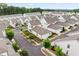 Aerial view showcases a community of homes with gray roofs, modern white exteriors, and lush greenery at 993 Harvest Park Ln, Suwanee, GA 30024