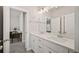 Bathroom featuring a double sink vanity with white cabinets and a large mirror at 993 Harvest Park Ln, Suwanee, GA 30024