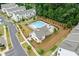 Aerial view of community pool with modern clubhouse and landscaping, perfect for summer relaxation at 993 Harvest Park Ln, Suwanee, GA 30024