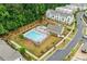 Relaxing community pool area with plenty of seating, a modern clubhouse, and lush landscaping at 993 Harvest Park Ln, Suwanee, GA 30024