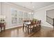 Elegant dining area featuring hardwood floors, plenty of natural light, and modern chandelier at 993 Harvest Park Ln, Suwanee, GA 30024