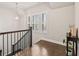 Landing area with hardwood floors, staircase, large window with shutters and stylish decor at 993 Harvest Park Ln, Suwanee, GA 30024