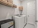 Well-organized laundry room with washer, dryer, shelving, and ample storage space at 993 Harvest Park Ln, Suwanee, GA 30024