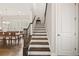 Staircase with wooden banister and white risers leading to the upper level, dining room visible at 993 Harvest Park Ln, Suwanee, GA 30024