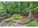 Lush backyard featuring a serene pond, rock features, a green lawn, and mature trees at 1291 Stillwood Ne Dr, Atlanta, GA 30306