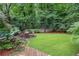 Lush backyard featuring a patio with outdoor seating, a green lawn, mature trees, and a water feature at 1291 Stillwood Ne Dr, Atlanta, GA 30306