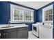 Laundry room with washer, dryer, gray cabinets, and black and white tile flooring at 1291 Stillwood Ne Dr, Atlanta, GA 30306