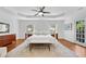 Bright main bedroom boasts a tray ceiling, hardwood floors, and french door access to a private balcony at 1291 Stillwood Ne Dr, Atlanta, GA 30306