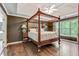 Spacious bedroom features a four-poster bed and a tray ceiling at 2073 Woodside Park Dr, Woodstock, GA 30188