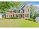 Beautiful brick home with lush green lawn and mature shade trees at 2073 Woodside Park Dr, Woodstock, GA 30188