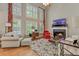 Elegant living room with a fireplace, hardwood floors, and lots of natural light at 2073 Woodside Park Dr, Woodstock, GA 30188