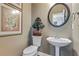 Charming half-bathroom features pedestal sink and decorative mirror at 2073 Woodside Park Dr, Woodstock, GA 30188