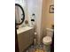 Stylish half-bath featuring elegant vanity, toilet, decorative mirror, and eye-catching patterned tile flooring at 36 Mount Tabor Rd, Covington, GA 30014