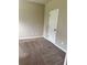 A bright, carpeted bedroom space with a door, perfect for relaxation at 3897 Valley Bluff Ln, Snellville, GA 30039