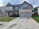 Traditional two-story home featuring a two-car garage and stone and siding exterior at 3897 Valley Bluff Ln, Snellville, GA 30039
