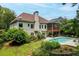 A backyard featuring a swimming pool, covered porch, and lush landscaping at 635 Piping Rock Pt, Lawrenceville, GA 30043