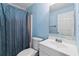 Bathroom with blue walls, a toilet, shower, and a white sink at 635 Piping Rock Pt, Lawrenceville, GA 30043