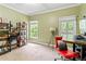Bright bedroom with two windows, bookshelves, a red chair, and desk at 635 Piping Rock Pt, Lawrenceville, GA 30043