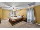 Bedroom featuring a tray ceiling, fan, and stylish curtains at 635 Piping Rock Pt, Lawrenceville, GA 30043