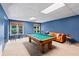 Bright game room featuring a billiard table, seating area, and natural light from two windows at 635 Piping Rock Pt, Lawrenceville, GA 30043