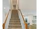 Carpeted staircase with white railing and wooden banister at 635 Piping Rock Pt, Lawrenceville, GA 30043
