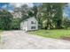 View of the home showing its garage, long driveway, stone porch, and landscaping at 1111 Fieldgate Nw Rd, Lilburn, GA 30044